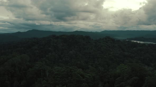 A beautiful dark cloudscape is hanging over a tropical forest after a rainy day alt