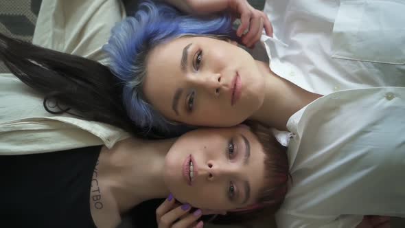 Beautiful Lesbian Women Posing for Photo Shoot Lying on Floor in Modern Interior alt