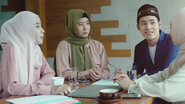 Upwardly mobile Asian Muslim business entrepreneur SME start up group of young man and women, discus alt