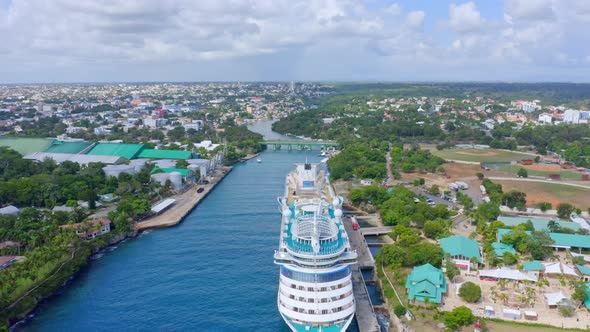 Luxury Cruise Ship Docked At Terminal In La Romana, Dominican Republic On A Sunny Day. - aerial pull alt
