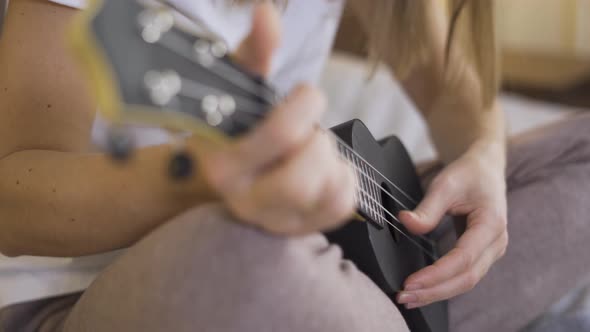 Close Up Hands Young Woman Playing Ukulele . Distance Learning Online Education