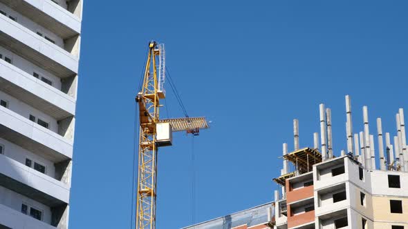 Construction of a Multi-storey Buildings. Construction Crane Turns Against the Sky.