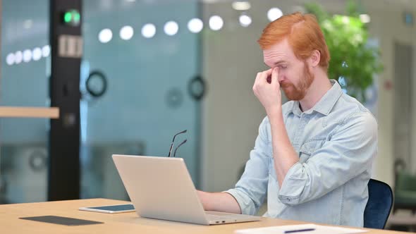 Stressed Casual Redhead Man with Laptop Having Headache in Office  alt