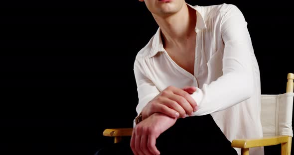 Androgynous man posing against black background alt