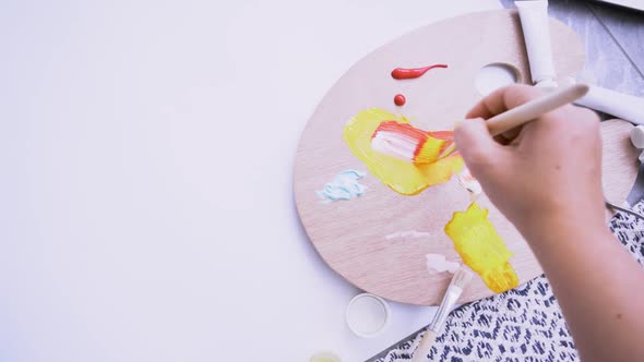 Woman Mixes Paint on Palette and Applying on Paper