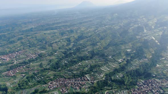 Terraced farmlands and Wonolelo village on Mount Merapi volcano slope, Indonesia alt