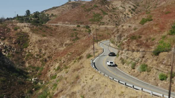 Black and White Exotic Sports Car Driving By Winding Road in Malibu