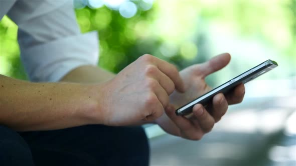 Businessman Using Smart Phone In Park. alt