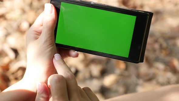 Woman in nature using green screen smart phone display 4K 2160p 30fps UltraHD video - Using smart ph