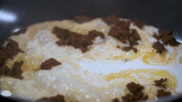 Stir Fry Panaeng Curry Paste with Fresh Coconut Milk in a Black Non Stick Pan alt