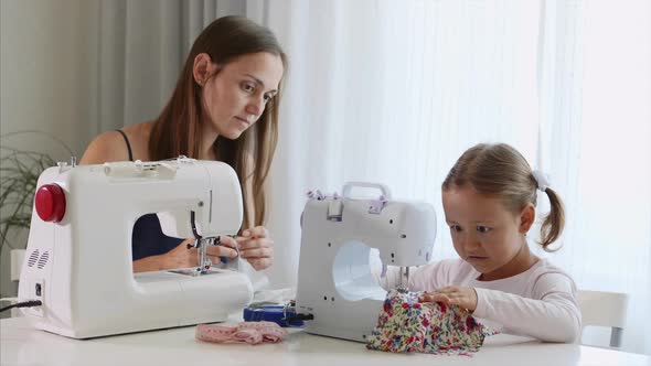 A Girl is Sewing on a Machine