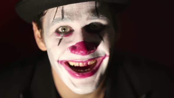 Terrible Clown Looks at the Camera and Laughs Terribly