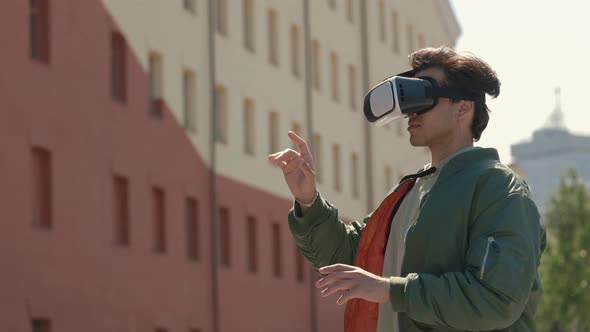 Stylish Guy Using VR Goggles for 3d Gaming Outdoors alt