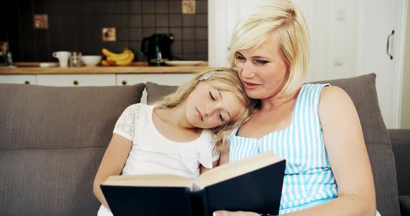 Mother Reading Book To Daughter