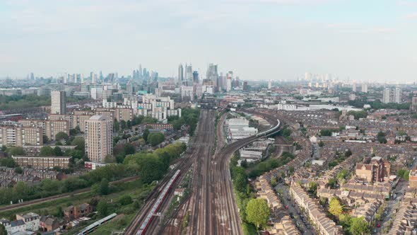 dolly forward drone shot of busy British rail train tracks towards London city centre alt