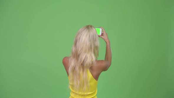 Young Beautiful Blonde Woman Taking Pictures with Phone