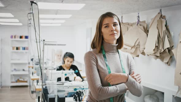Female Tailor with Tape Measure on Neck is Smiling While Posing at Workshop Seamstresses Working at alt