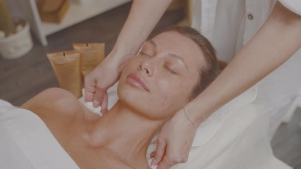 Cosmetologist in Beauty Salon Wipes Skin Face and Neck with Cotton Pads Tonic alt