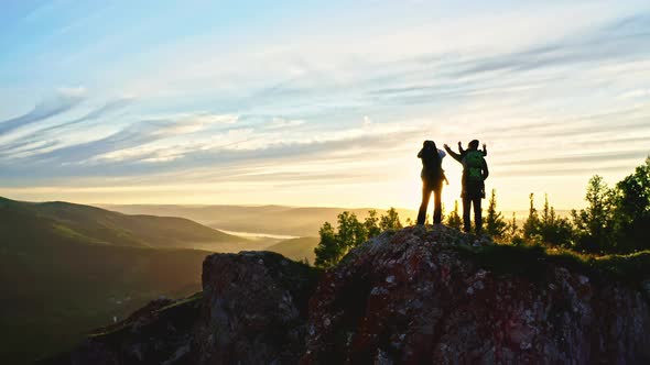 Silhouette Young Happy Parents and Children Sitting in a Carrier Cheerfully Raise Their Hands at alt