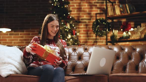 Girl Holds Xmas Gift Box Opens Christmas Present Video Call Virtual Meeting Chat With Family alt