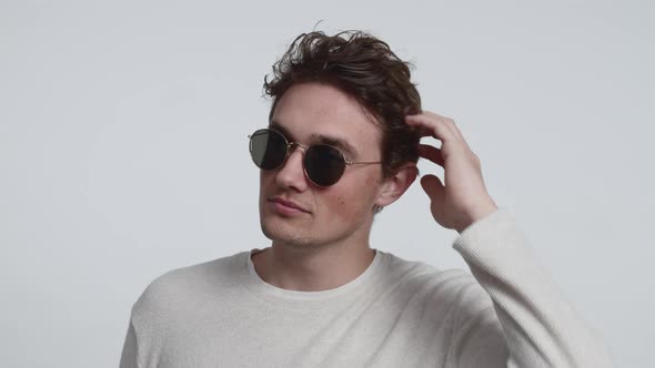Attractive Male Model Wearing Sunglasses with White Studio Background alt