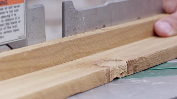 Close up view of board being cut by miter saw at an angle alt