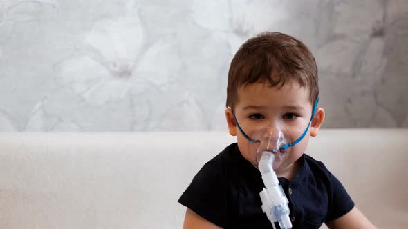 Slow Motion Portrait of a Little Boy in a Medical Mask for Inhalation