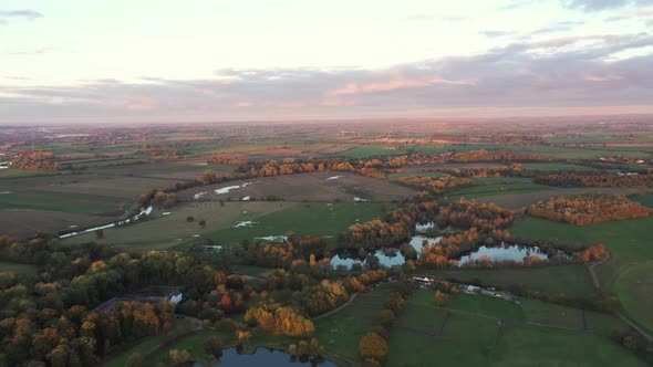 Aerial view of green countryside and cultivated fields at sunset