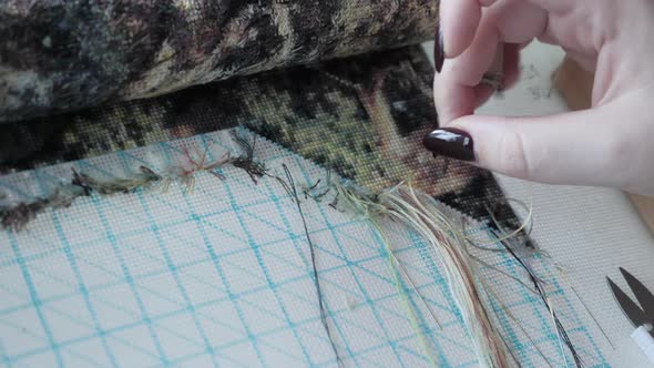 Cross stitching. Woman makes embroidery beautiful picture of nature. alt