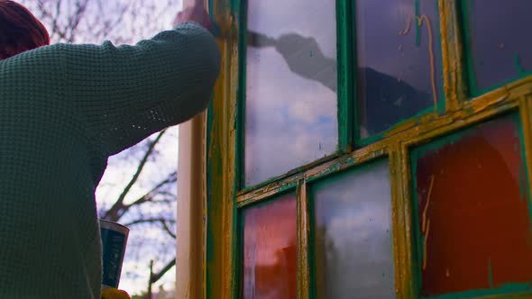 Close Up of Unrecognizable Person Paints Window with Yellow Paint on Street alt