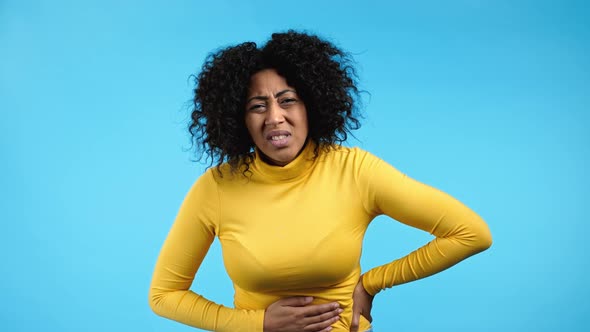 Young African Woman Squeezing Belly with Hands Because of Abdominal Pain alt