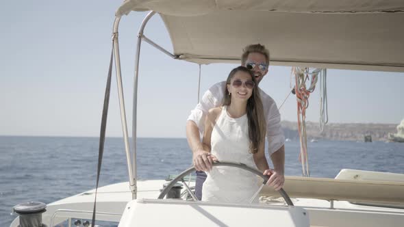 Rich Couple Steering Their Yacht