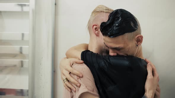 Two Sexy Guys in Tshirts Standing Under Water in the Shower and Hugging alt