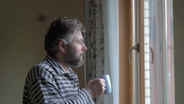 A man looks at today's weather through a window