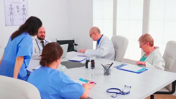 Doctor Specialist Briefing His Medical Team in Hospital Conference Room alt