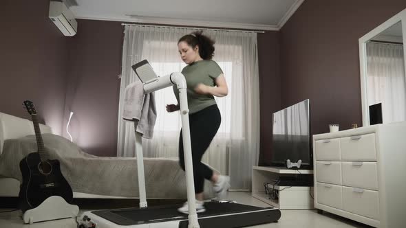 Training on treadmill at home. Home fitness workout. alt