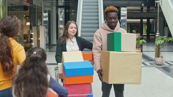 Happy Multiethnic Couple Walking With Shopping Bags in the Mall alt