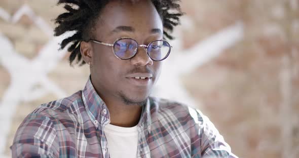 Close-up of Smiling Young African American Man in Eyeglasses Showing Thumb Up and Clapping Hands in alt