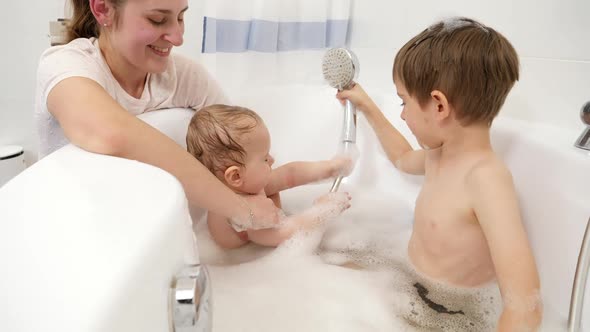 Happy Children Having Fun and Playing with Foam and Shower in Bathroom alt