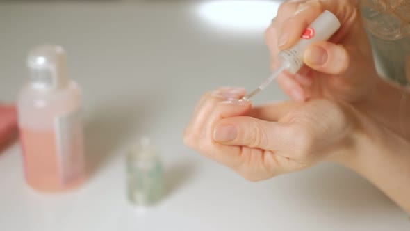 A Woman Does Her Own Manicure on Her Hands at Home