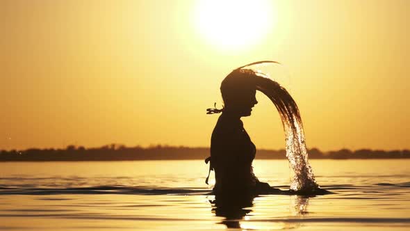 Silhouette of Woman Flipping Her Long Hair Back in Water. Slow Motion 240 Fps alt
