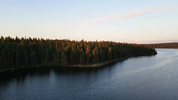 Soft light at sunset illuminating the trees surrounding Cobb Lake in British Columbia, Canada. Wide alt