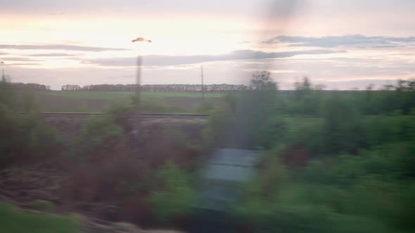 View From Window of Highspeed Train on Landscape of Beautiful Nature Field Village Houses and Forest