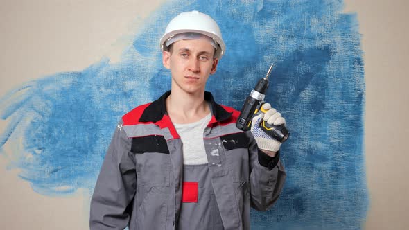 Worker Switches on Cordless Drill and Shows Approval Gesture alt