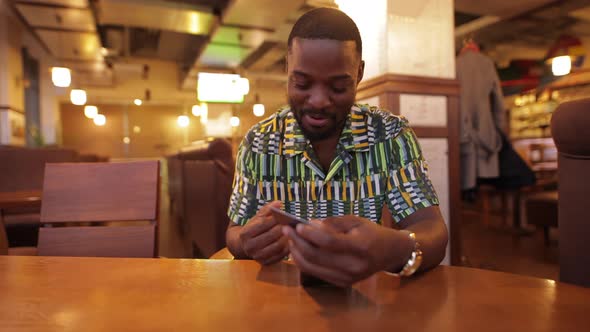 AfricanAmerican Man Win a Jackpot Looking in Smartphone