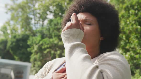 Video of plus size african american woman using inhalator outdoors alt