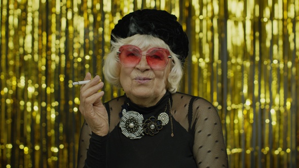 Elderly Style Mature Businesswoman in Fashion Black Clothes in Sunglasses Posing, Smoke Cigarette alt