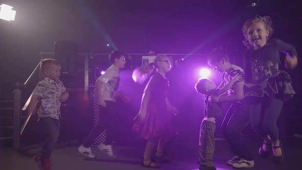 Young Children Dancing Happily at a Disco Party with Bright Lights - Ungraded alt