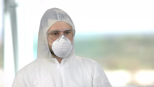 Portrait of a Man Wearing White Protective Clothing with Mask and Glasses alt