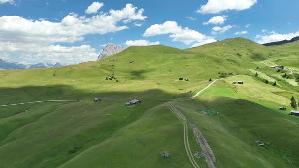Dolomites Mountains with hiking paths and wooden cottages alt